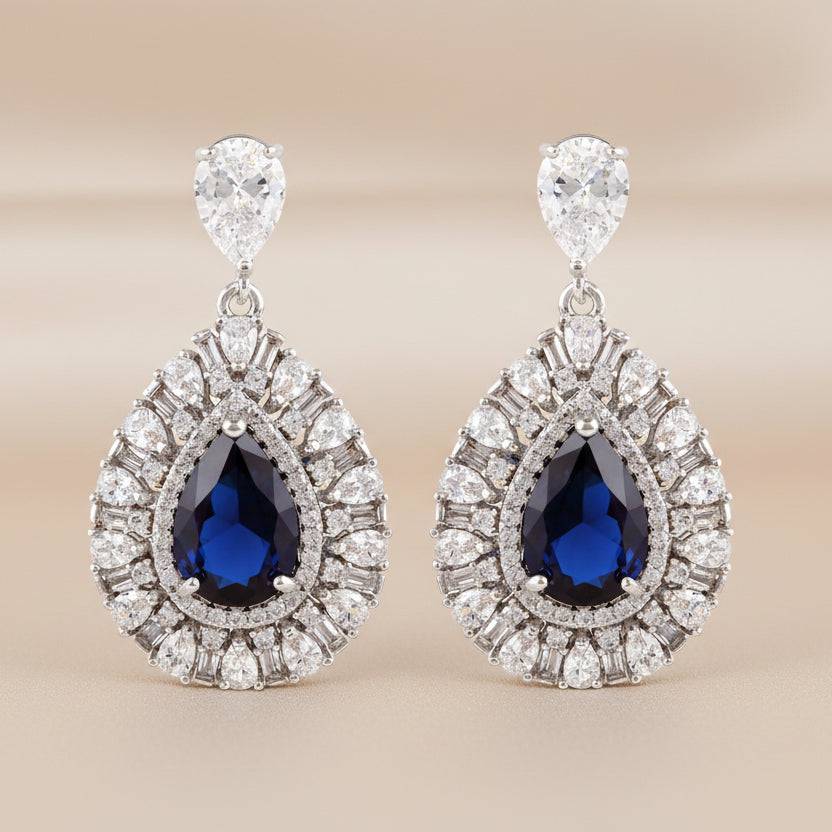 Rhodium drop-shaped earrings featuring luxury zircon stones by Bound Jewels, elegantly displayed against a soft background.